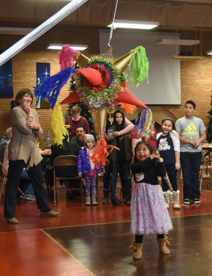 Diana Manuel gives the pinata a good kick as her friends wait for their turn at Las Posadas at Grace Lutheran Church on December 19.