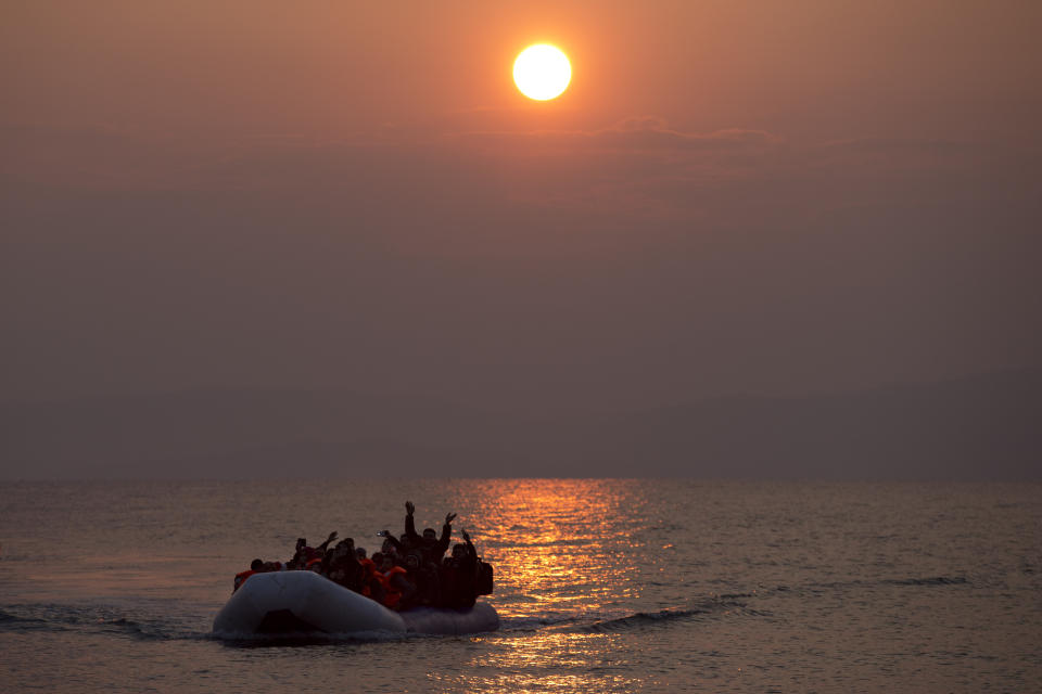 ARCHIVO - En esta imagen de archivo del domingo 20 de marzo de 2016, sale el sol mientras migrantes y refugiados llegan en una lancha a la costa nordeste de la isla griega de Lesbos, tras cruzar el Mar Egeo desde Turquía. (AP Foto/Petros Giannakouris, Archivo)