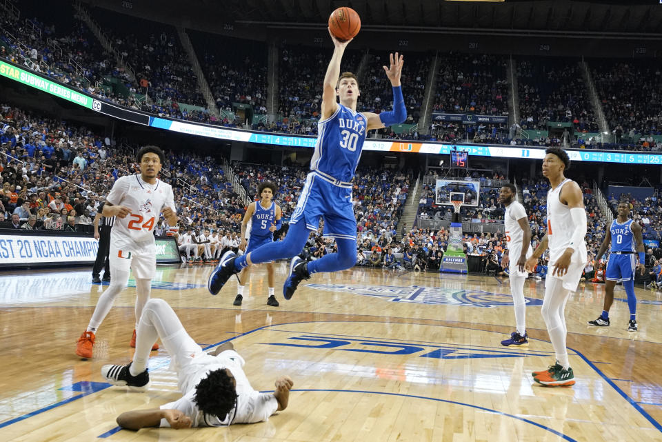 Duke center Kyle Filipowski (30) shoots over fallen Miami forward Anthony Walker, front left, during the second half of an NCAA college basketball game at the Atlantic Coast Conference Tournament in Greensboro, N.C., Friday, March 10, 2023. (AP Photo/Chuck Burton)