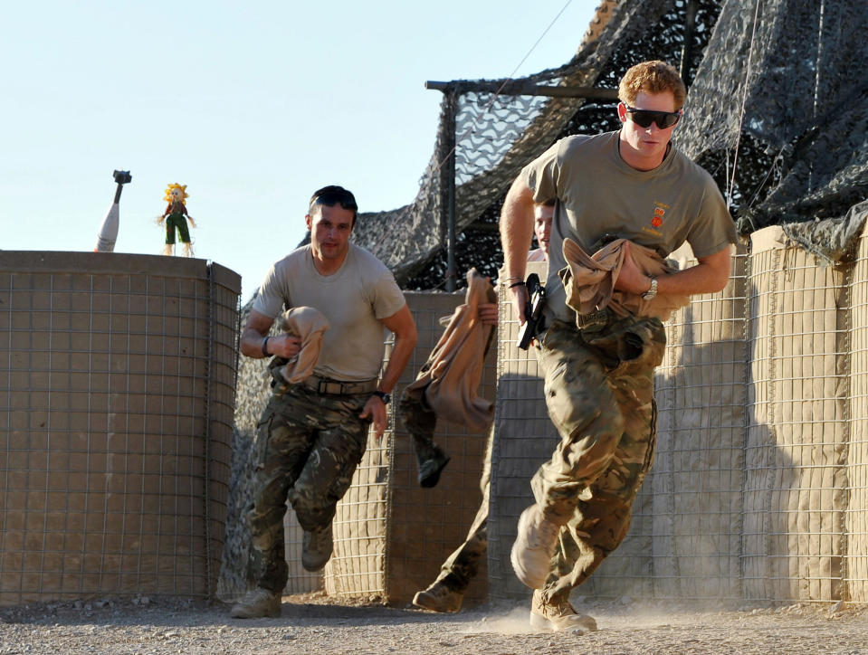 FILE - In this Nov. 3, 2012 file photo, Britain's Prince Harry, right, or just plain Captain Wales as he is known in the British Army, races out from the VHR (very high readiness) tent to scramble his Apache with fellow pilots, during his 12-hour shift at the British-controlled flight-line in Camp Bastion southern Afghanistan. Palace officials say that Prince Harry is ending his role as a helicopter pilot and taking up a new job with the army in London. Kensington Palace said Harry will now be organizing "major commemorative events" involving the army. (AP Photo/ John Stillwell, Pool, File)