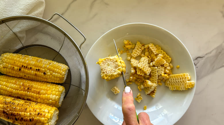 hand cutting corn off cob