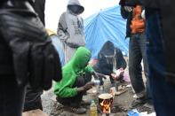 Migrants cook food ahead of their evacuation from the "Jungle" migrant camp in Calais, northern France, on October 24, 2016