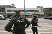 Police officers look on after a knife attack in a supermarket in Hamburg. REUTERS/Morris Mac Matzen