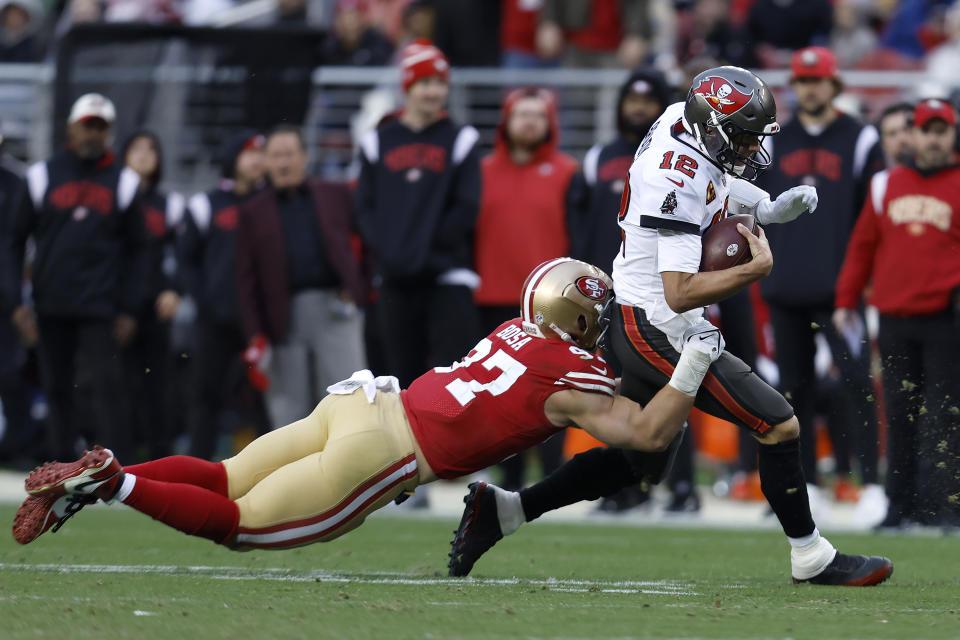 Tom Brady, quarterback de los Buccaneers de Tampa Bay, acarrea el balón frente a Nick Bosa, de los 49ers de San Francisco, en el partido del domingo 11 de diciembre de 2022 (AP Foto/Jed Jacobsohn)