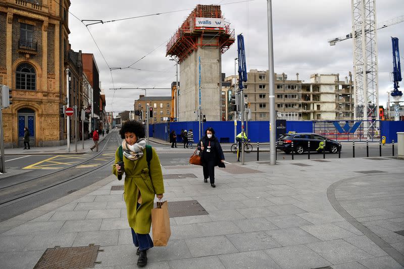People walk near a demolition site in Dublin