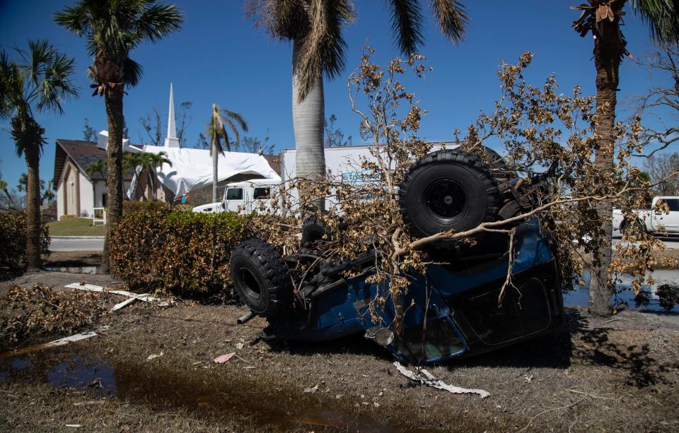 McGregor Boulevard near the Sanibel Outlets in Fort Myers, Fla., was devastated by the storm. In the background, workers seal the damaged roof of Southwest Baptist Church.