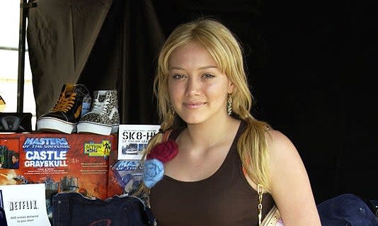 Close-up of Hilary next to display items, including sneakers and a Netflix offer