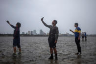 <p><strong>Tampa</strong><br>The Tampa skyline is seen in the background as local residents (L-R) Rony Ordonez, Jean Dejesus and Henry Gallego take photographs after walking into Hillsborough Bay ahead of Hurricane Irma in Tampa, Fla. on Sept. 10, 2017. (Photo: Adrees Latif/Reuters) </p>