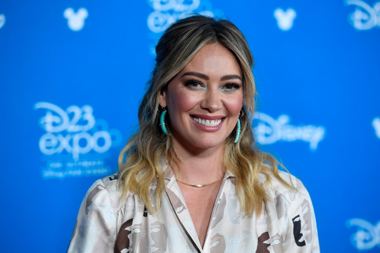 Hilary Duff smiles while posing at the D23 expo