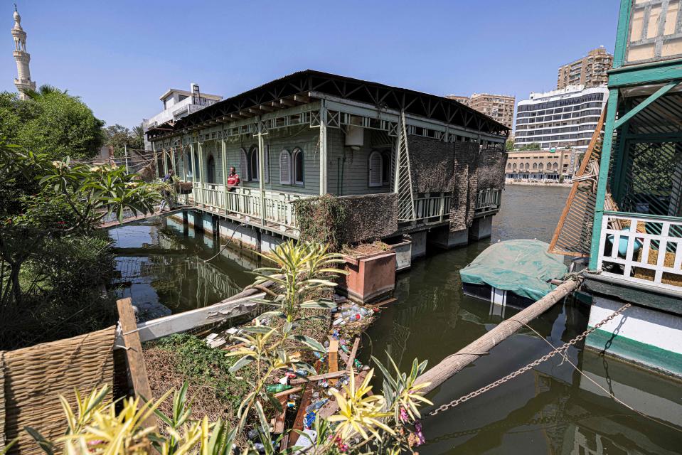 Permanent houseboats on the Nile with connected gardens on land.