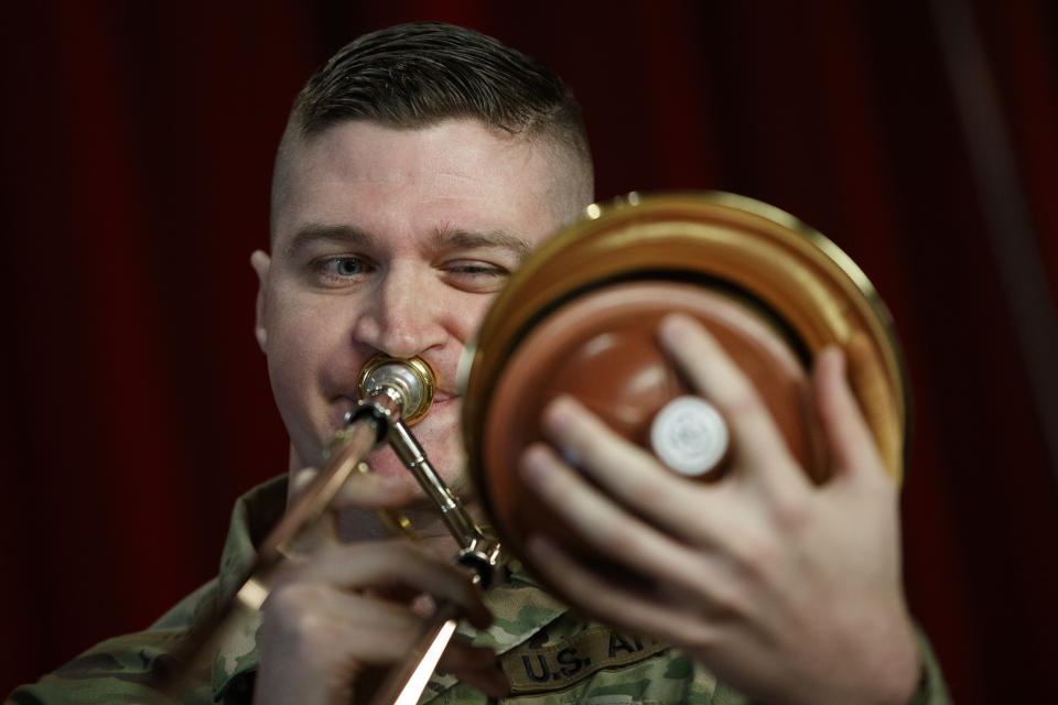 U.S. Army Field Band member Staff Sgt. Kyle Johnson, originally form College Station, Texas, plays the trombone during rehearsal of their daily "We Stand Ready" virtual concert series at Fort George G. Meade in Fort Meade, Md., Wednesday, March 25, 2020. The Army Field Band's mission is to bring the military's story to the American people. And they're not letting the coronavirus get in the way. (AP Photo/Carolyn Kaster)