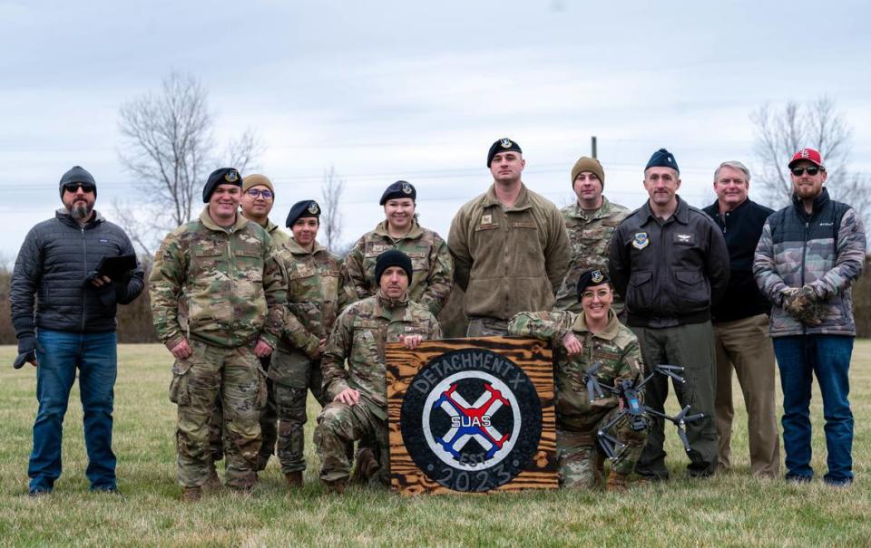 U.S. Air Force Airmen pose for a photo with a drone and a Detachment X landing board at the Belle Clair Soccer Park in Belleville. Detachment X is a program designed to train individuals from different careers to be efficient in drone flying.