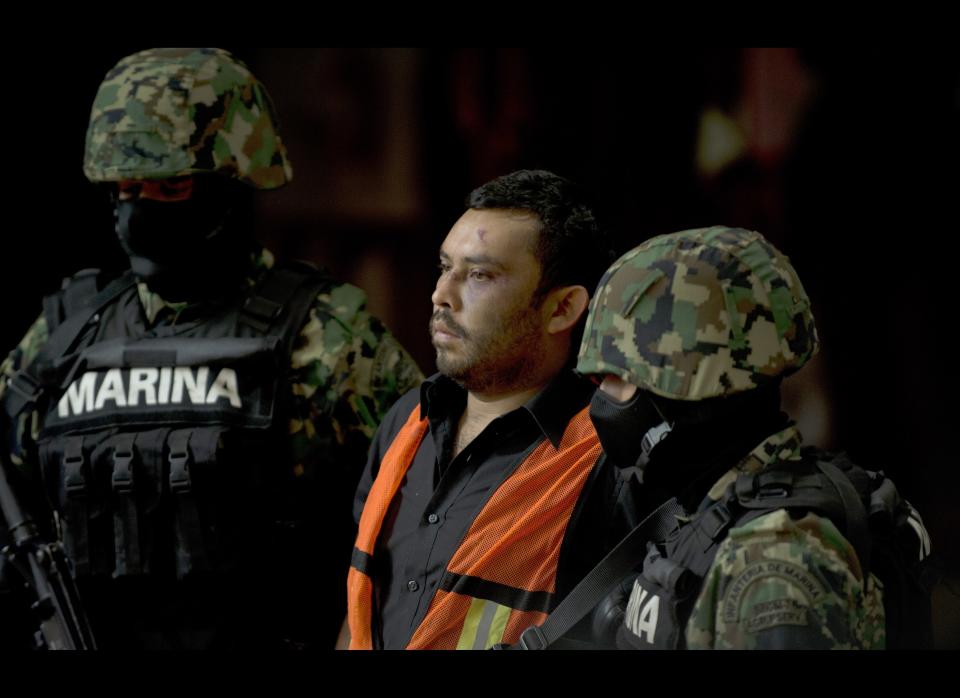 Mexican marines escort Marcos Jesus Hernandez Rodriguez, aka 'El Chilango', alleged leader of assassins and member of the Los Zetas drug cartel, in Veracruz state, during his presentation for the press in Mexico City on May 11, 2012. (YURI CORTEZ/AFP/GettyImages)