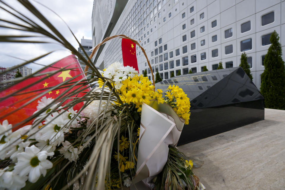 A Chinese flag is placed near flowers on a monument at the site of a former Chinese Embassy in Belgrade, Serbia, Saturday, May 4, 2024. Chinese leader Xi Jinping's visit to European ally Serbia on Tuesday falls on a symbolic date: the 25th anniversary of the bombing of the Chinese Embassy in Belgrade during NATO's air war over Kosovo. (AP Photo/Darko Vojinovic)