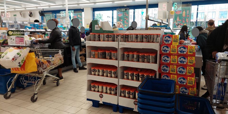 Lidl checkout in Peckham, London, UK. Customers stand paying for groceries