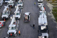 Workers gas up rows of trucks after a day's work at a tent city in Amelia, La., Thursday, Sept. 16, 2021. When Ida came ashore on Aug. 29, it knocked out power to about 1.1 million customers in the state. (AP Photo/Gerald Herbert)