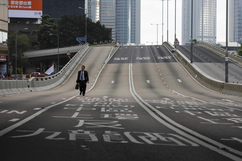 FILE - In this June 17, 2019, file photo, a man walks alone on normally busy road near the Legislative Council after protesters continue to protest against the extradition bill in Hong Kong. Hong Kong’s embattled leader Carrie Lam said Tuesday that the city’s economy is being battered by months of increasingly violent protests. (AP Photo/Vincent Yu, File)