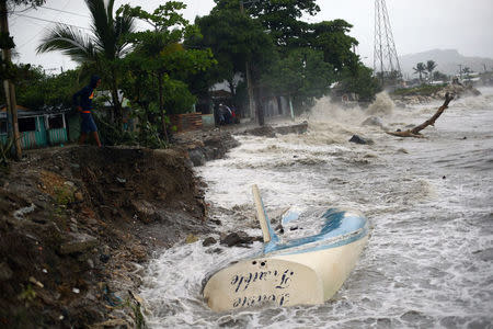 Waves crash against the shore and a stranded boat as Hurricane Irma moves off from the northern coast of the Dominican Republic, in Puerto Plata, Dominican Republic September 7, 2017. REUTERS/Ivan Alvarado