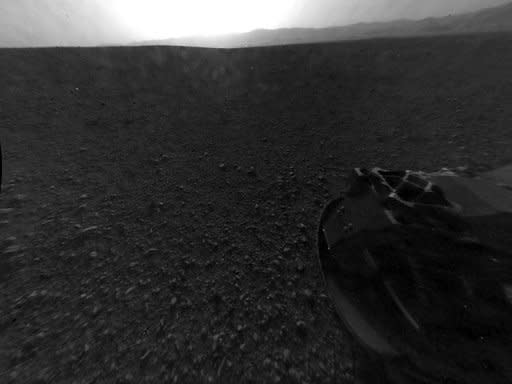 Image provided by NASA on August 7 shows one of the first images of Mars taken by a rear Hazard-Avoidance camera on the Curiosity rover. On Wednesday, NASA plans to lift the rover's remote sensing mast for the first time. More images, including color high-resolution shots, are expected to arrive in the coming days