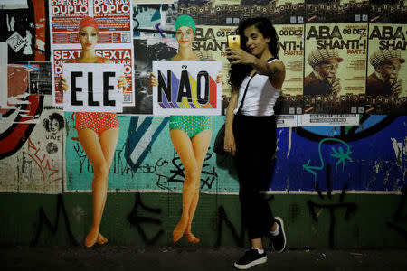 A woman takes a selfie near a signs reading "NotHim" during a demonstration against Brazil's presidential candidate Jair Bolsonaro, in Sao Paulo, Brazil September 29, 2018. REUTERS/Nacho Doce