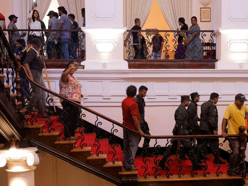 Protesters took pictures after entering the president’s house (REUTERS)