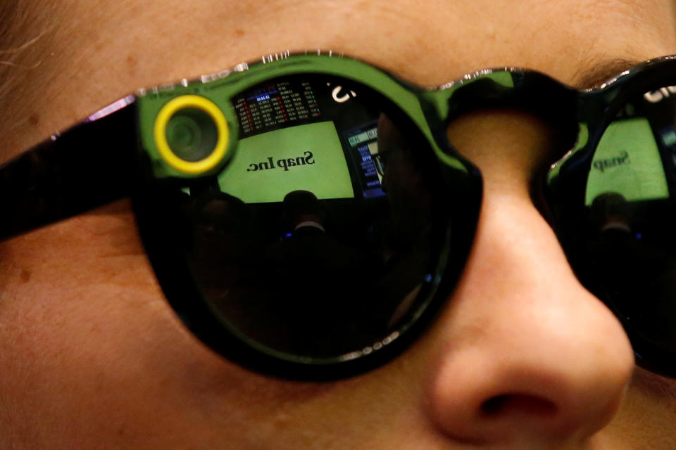 A woman wearing Snapchat Spectacles waits for Snap Inc. to list their IPO on the NYSE, March 2, 2017. REUTERS/Brendan McDermid