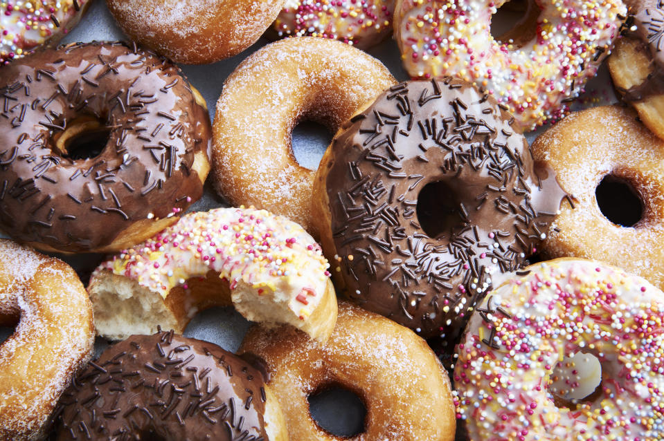 A mixture of trans fats iced chocolate and regular ring doughnuts.