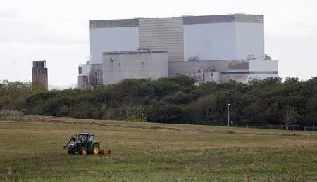 A tractor mows a field on the site where EDF Energy's Hinkley Point C nuclear power station will be constructed in Bridgwater, southwest England, in this file photograph dated October 24, 2013. REUTERS/Suzanne Plunkett/files