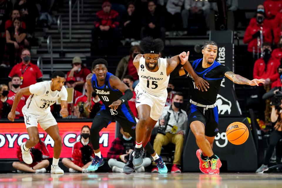 Cincinnati Bearcats forward John Newman III (15) and Tulsa Golden Hurricane guard Darien Jackson (11) compete for a loose ball in the first half of an NCAA men's college basketball game, Thursday, Jan. 20, 2022, at Fifth Third Arena in Cincinnati.