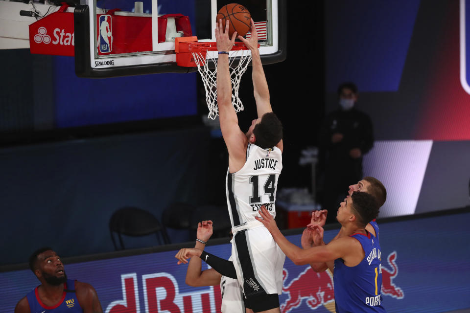 San Antonio Spurs forward Drew Eubanks (14) dunks against Denver Nuggets forward Michael Porter Jr. (1) during the first half of an NBA basketball game, Wednesday, Aug. 5, 2020, in Lake Buena Vista, Fla. (Kim Klement/Pool Photo via AP)