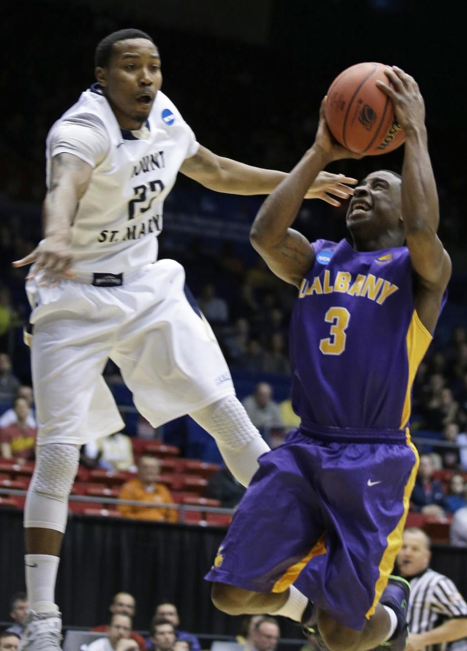 Albany guard DJ Evans (3) drives against Mount St. Mary's guard Julian Norfleet in the first half of a first-round game of the NCAA college basketball tournament, Tuesday, March 18, 2014, in Dayton, Ohio. (AP Photo/Al Behrman)