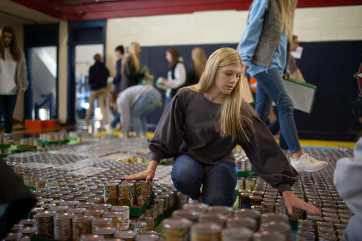 Senior Ava Zientak packs cans and packages of nonperishable foods for distribution to local churches and nonprofit organizations at Columbia Academy in Columbia, Tenn., on Tuesday, Nov. 23, 2021.