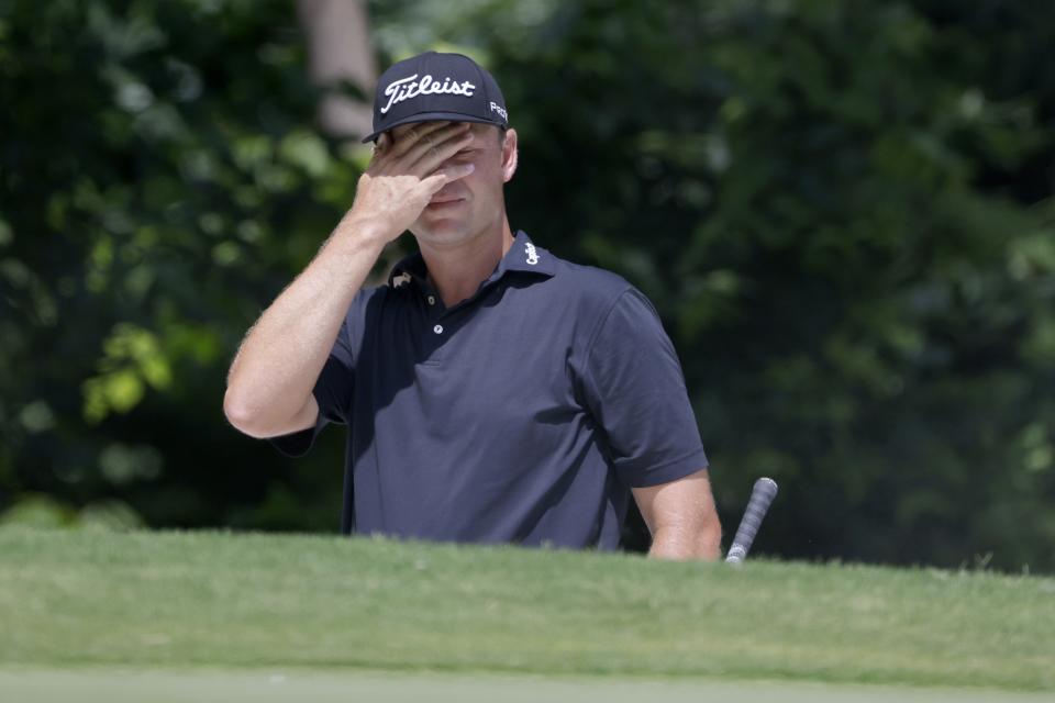 Patton Kizzire wipes sand off his face after hitting out of a bunker onto the fifth green during the third round of the Charles Schwab Challenge golf tournament at Colonial Country Club in Fort Worth, Texas, Saturday, May 29, 2021. (AP Photo/Ron Jenkins)