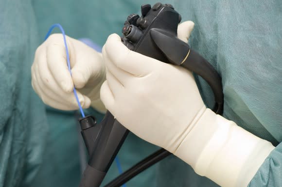 Gloved hands of a doctor using an endoscope