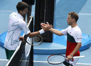 Serbia's Novak Djokovic, left, is congratulated by Diego Schwartzman of Argentina after winning their fourth round singles match at the Australian Open tennis championship in Melbourne, Australia, Sunday, Jan. 26, 2020. (AP Photo/Andy Wong)