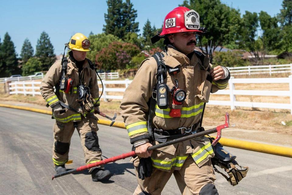 Cal Fire Merced County firefighters and City of Merced firefighters battle a structure fire which damaged two homes in the 1800 block of Dunn Road in Merced County, Calif., on Wednesday, Aug. 23, 2023. Fire officials said the cause of the fire is under investigation.