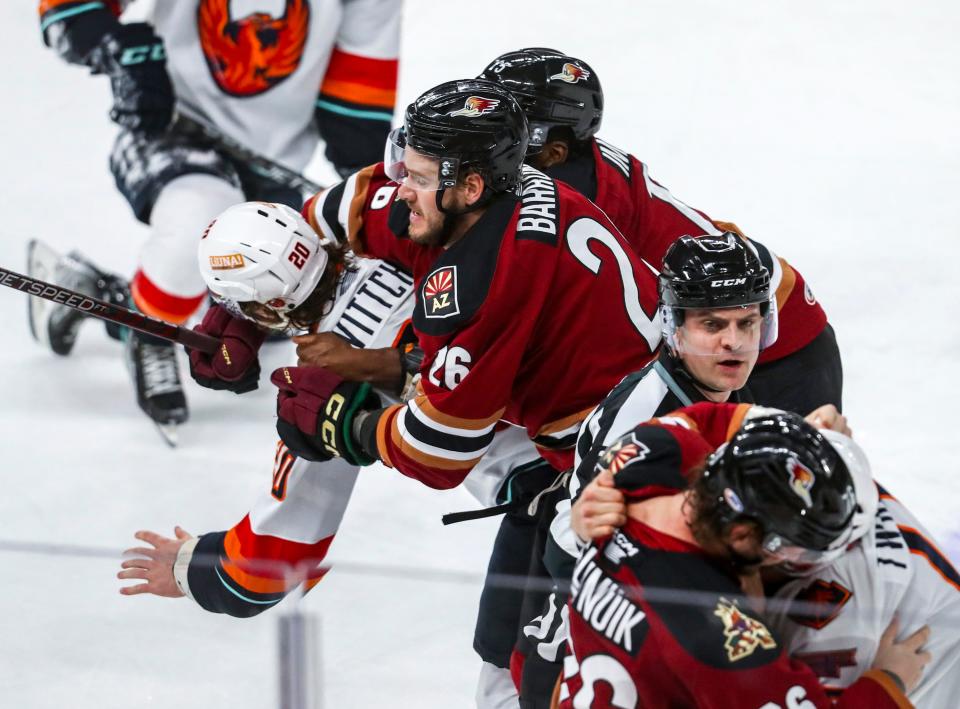 Coachella Valley forward Eddie Wittchow (20) and Tucson left wing Travis Barron (26) get into a brief altercation as Tucson forward Hudson Elynuik (76) gets into it with Coachella Valley forward Carsen Twarynski (18) during the first period of their game at Acrisure Arena in Palm Desert, Calif., Tuesday, Dec. 20, 2022. 