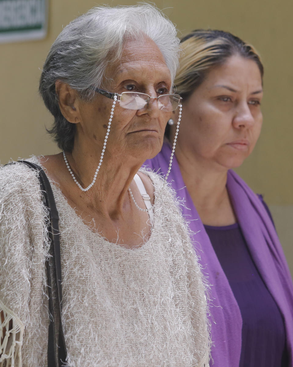 Carmen Arevalo de Acosta, left, and Carmen Acosta, mother and sister of Navy Captain Rafael Acosta walk out of the morgue in Caracas, Venezuela, Wednesday July 10, 2019. Rafael Acosta, a Venezuelan navy captain who died of suspected torture while in government custody, was buried by authorities against the family's wishes to perform a private ceremony, an attorney and relatives said. (AP Photo/Leonardo Fernandez)