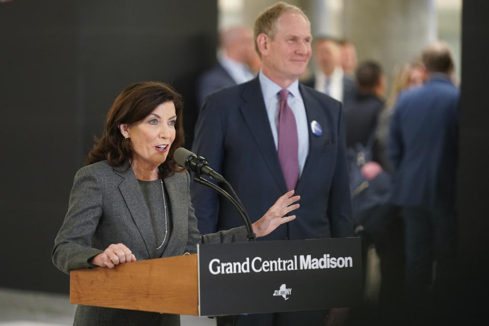 New York Gov. Kathy Hochul speaks, as Janno Lieber, CEO of the MTA, listens, during a news conference in the new annex of Grand Central Station in New York, Wednesday, Jan. 25, 2023. After years of delays and massive cost overruns, one of the world's most expensive railway projects on Wednesday began shuttling its first passengers between Long Island to a new annex to New York City's iconic Grand Central Terminal (AP Photo/Seth Wenig)