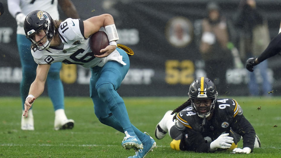 Jacksonville Jaguars quarterback Trevor Lawrence (16) slips a tackle by Pittsburgh Steelers defensive tackle Armon Watts (94) during the first half of an NFL football game Sunday, Oct. 29, 2023, in Pittsburgh. (AP Photo/Matt Freed)