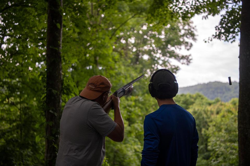 Michael Pramik, left, fires a shotgun at sporting clays at Summit Bechtel National Scout Preserve, alongside guide Joey Oliver.