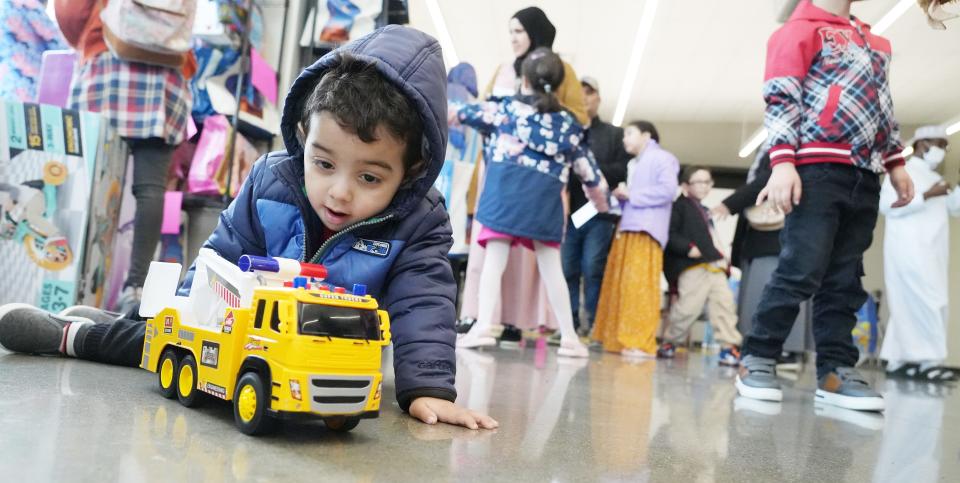 Adam Bouchaib, 2, plays with his new truck during the Our Helpers toy drive. More than 800 toys were given away to needy families, many of them from refugee backgrounds, on Friday at the Linden Community Center.