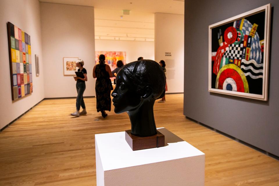 "Glory" a cast bronze with a black patina on a wooden base created by Elizabeth Catlett is displayed with artwork in the "Homecoming" exhibition, which comprises a series of installations, Tuesday, Aug. 23, 2022, at the Stanley Museum of Art on the University of Iowa campus in Iowa City, Iowa.