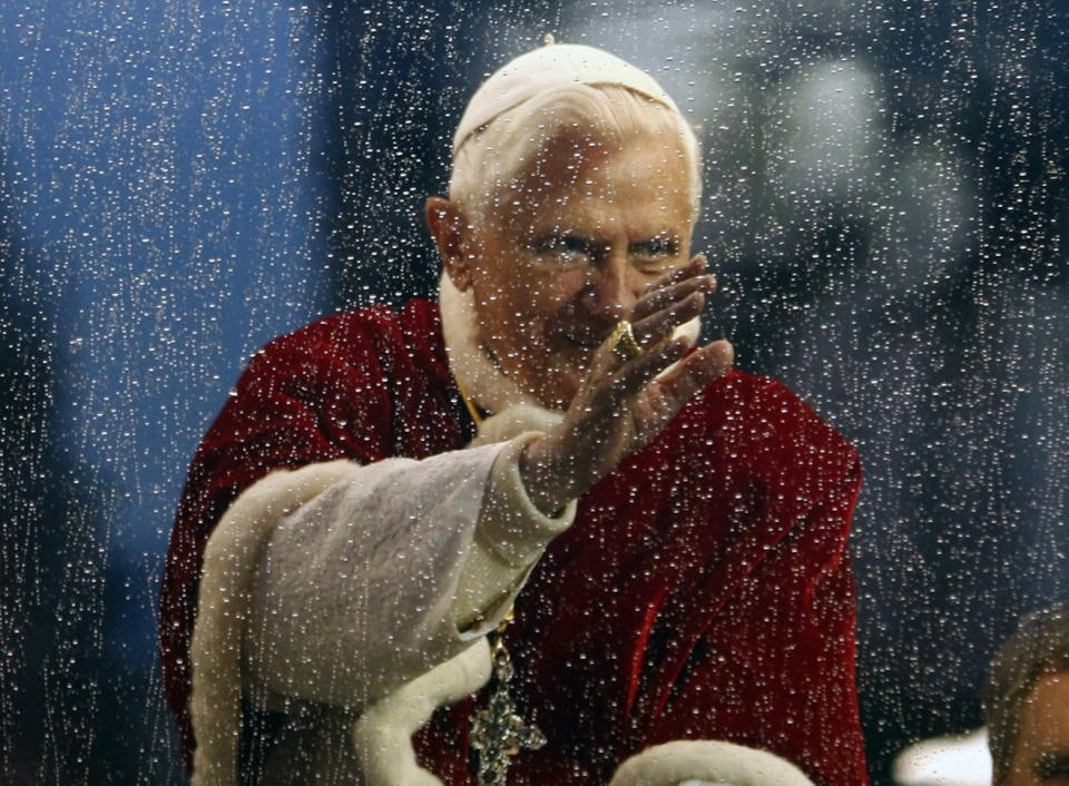 FILE - Pope Benedict XVI waves from his pope mobile as it rains, after the traditional prayer to celebrate the Immaculate Conception, in Rome, on Dec. 8, 2009. When Cardinal Joseph Ratzinger became Pope Benedict XVI and was thrust into the footsteps of his beloved and charismatic predecessor, he said he felt a guillotine had come down on him. The Vatican announced Saturday Dec. 31, 2022 that Benedict, the former Joseph Ratzinger, had died at age 95. (AP Photo/Pier Paolo Cito, File)