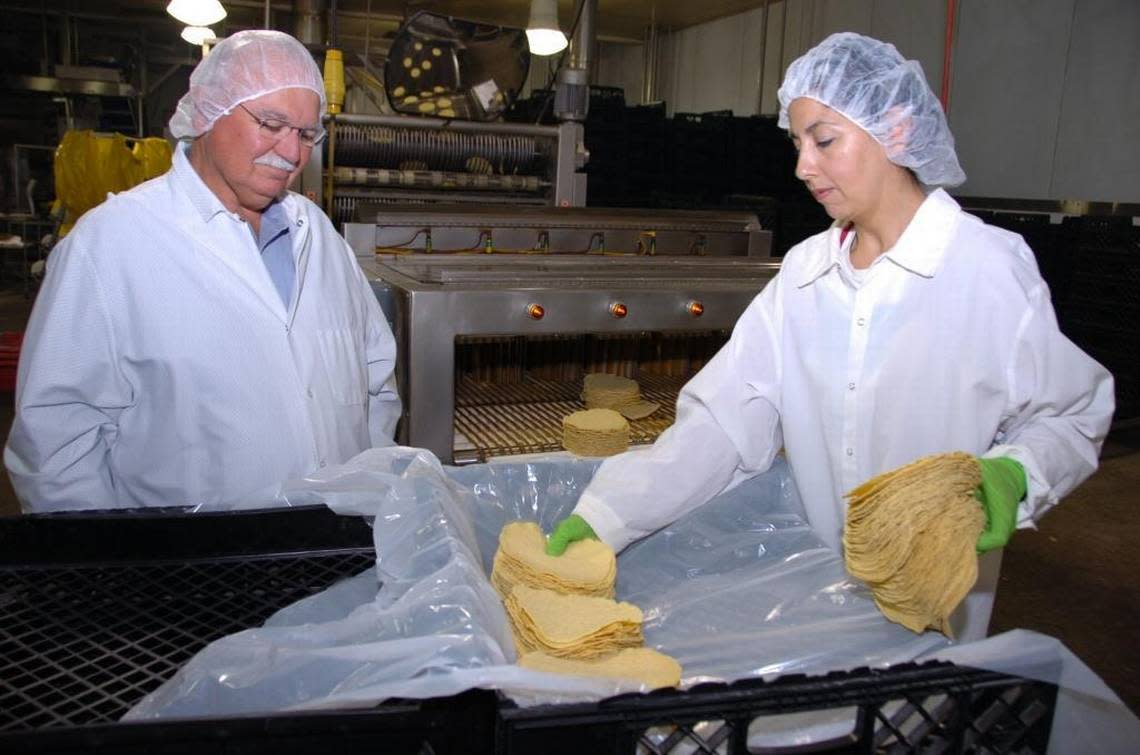 In this 2011 photo, Ruiz Foods co-founder Fred Ruiz talks with worker Martha Arevalo at the plant in Dinuba. While the company will consolidate its corporate headquarters in Texas, the Dinuba and Tulare manufacturing plants will remain. HAND OUT/Fresno Bee file photo