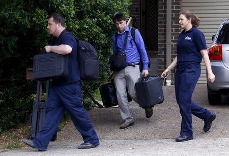 Federal police officers carry equipment as they exit a house after arresting a man during early morning raids in western Sydney, Australia, October 7, 2015. REUTERS/David Gray