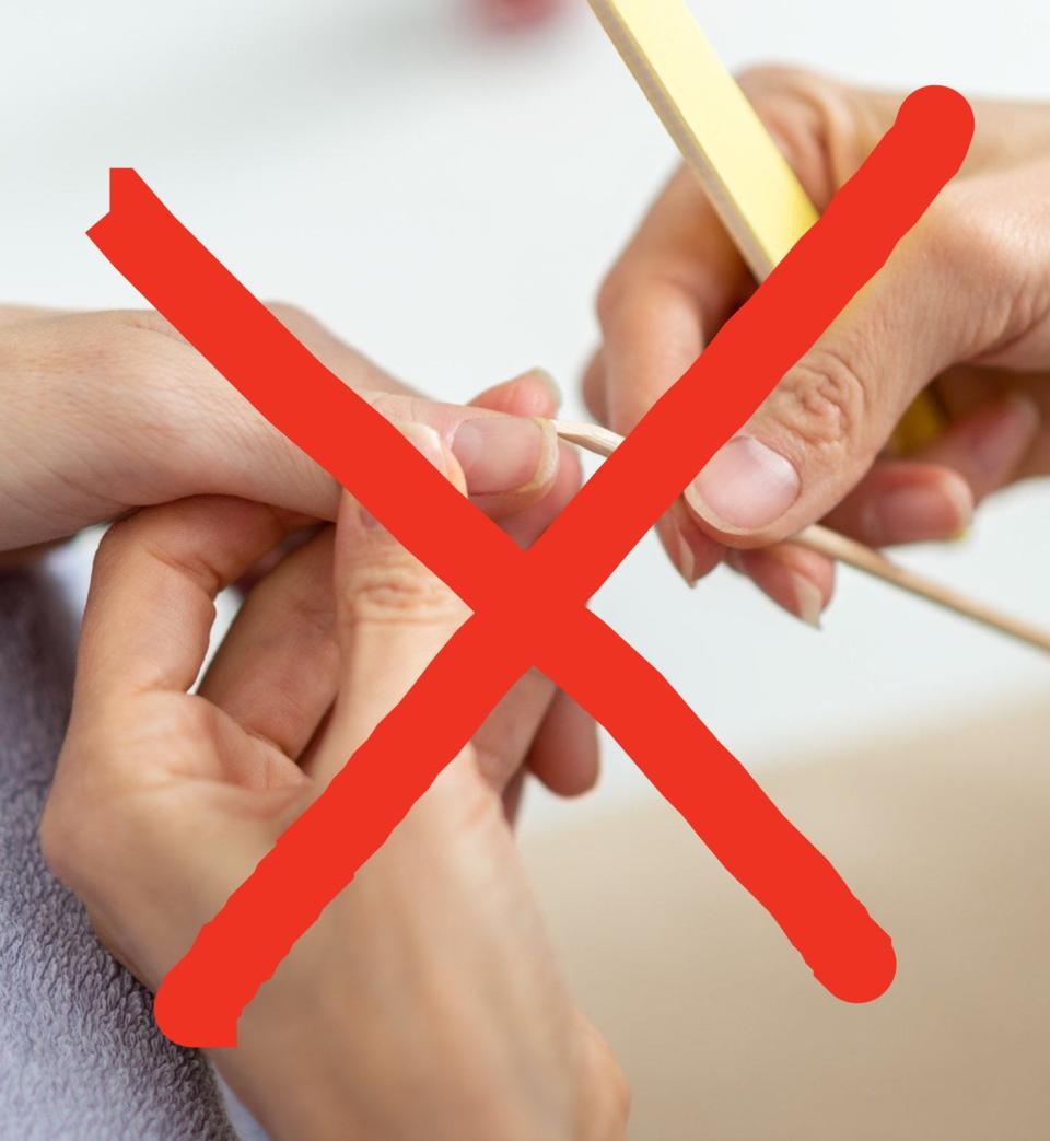 image of a nail technician cleaning behind nail