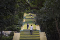 People climb stairs painted in the colors of Brazil's flag ahead of the World Cup in Rio de Janeiro, Brazil, Wednesday, May 14, 2014. The international soccer tournament will be the first in the South American nation since 1950. (AP Photo/Felipe Dana)