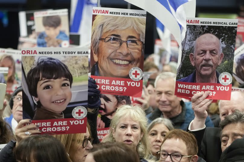 A person holds a poster of the late Vivian Silver as health professionals attend a demonstration in front of the International Committee of the Red Cross in London