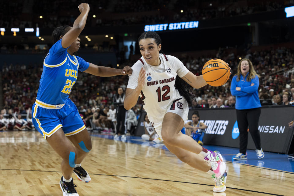 South Carolina's Brea Beal (12) dribbles by UCLA's Charisma Osborne (20) in the first half of a Sweet 16 college basketball game at the NCAA Tournament in Greenville, S.C., Saturday, March 25, 2023. (AP Photo/Mic Smith)